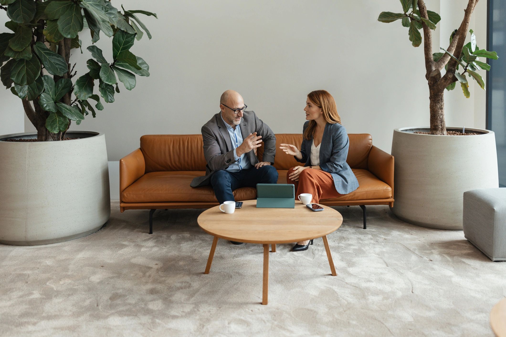 Two professionals reviewing information on a tablet